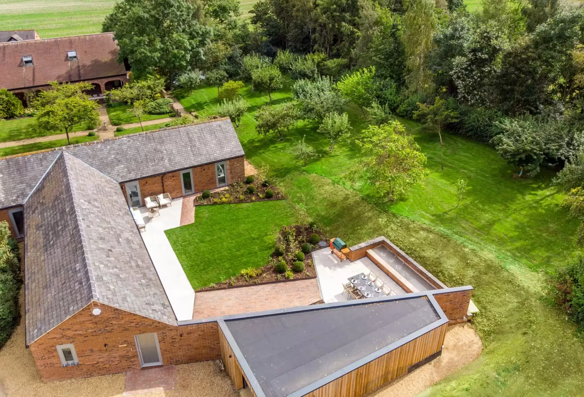 Aerial view of The Barn at Clipston with its terrace, outdoor dining and orchard