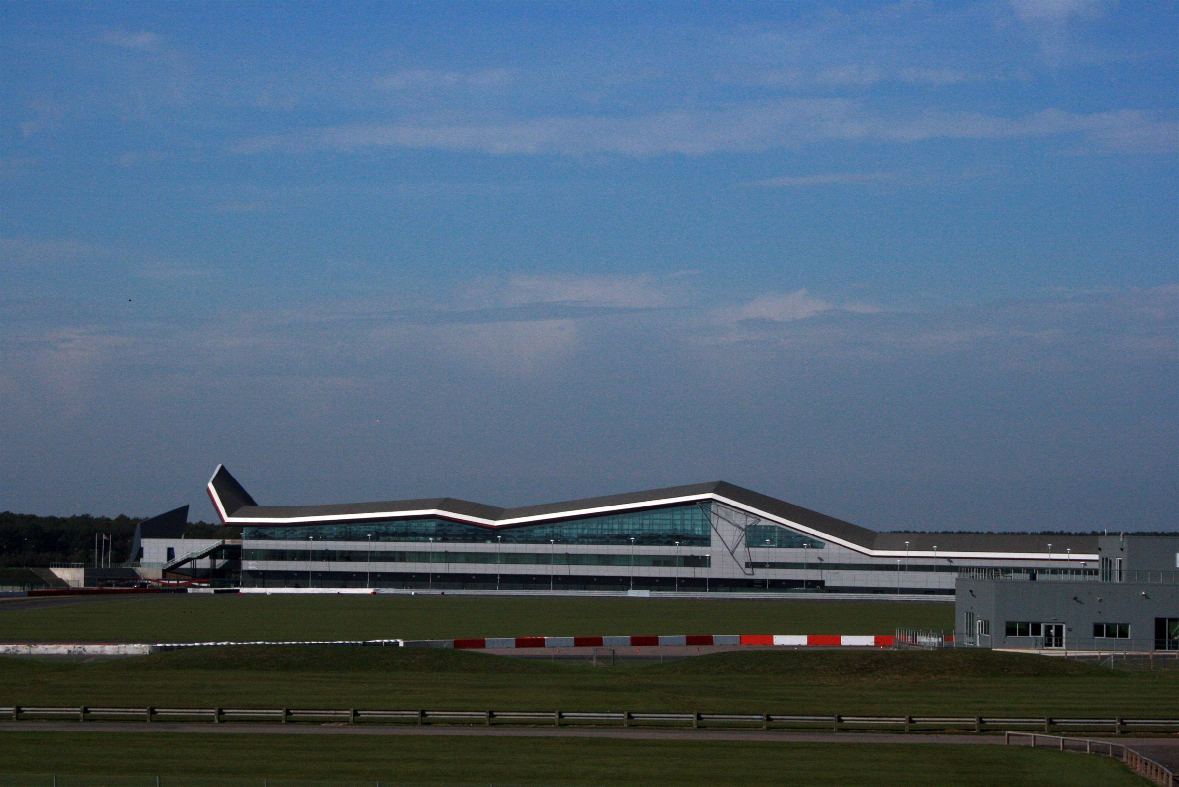 The Wing pit and paddock building at Silverstone Circuit seen across the grass from the infield