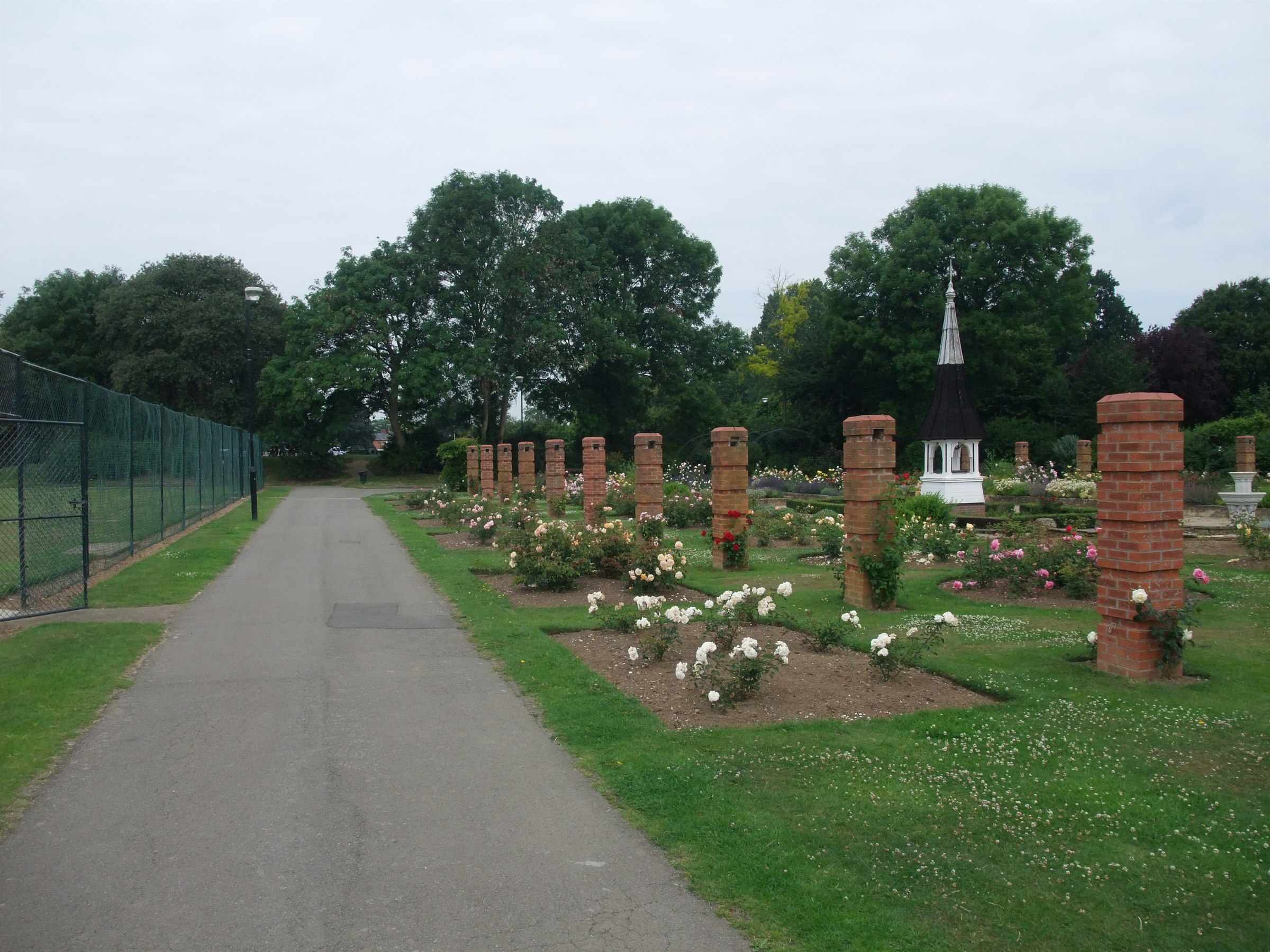 The rose garden in Welland Park Market Harborough with brick pillars and a white timber cupola