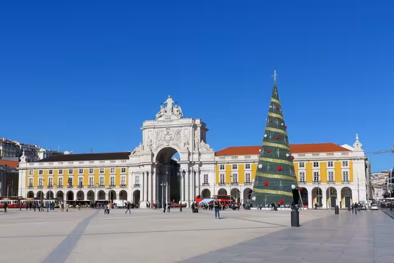 The Christmas tree on Praca do Comercio in Lisbon in front of the Rua Augusta Arch on a sunny December day