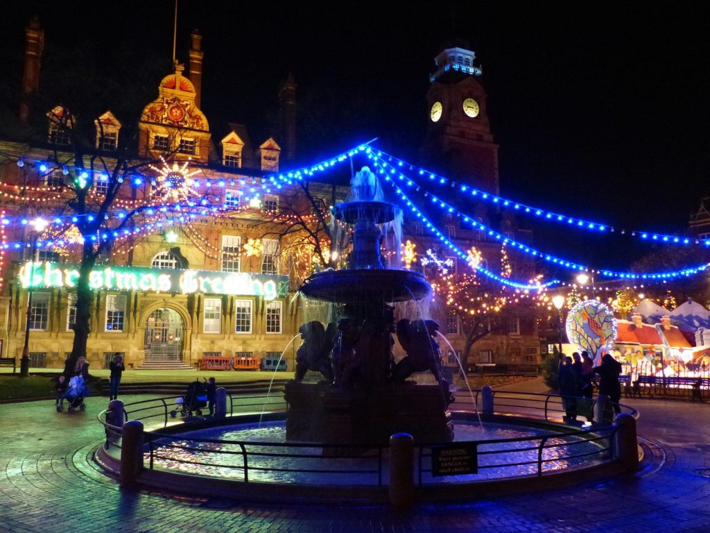 Leicester Town Hall Square at night with blue Christmas lights strung over the fountain and festive decorations
