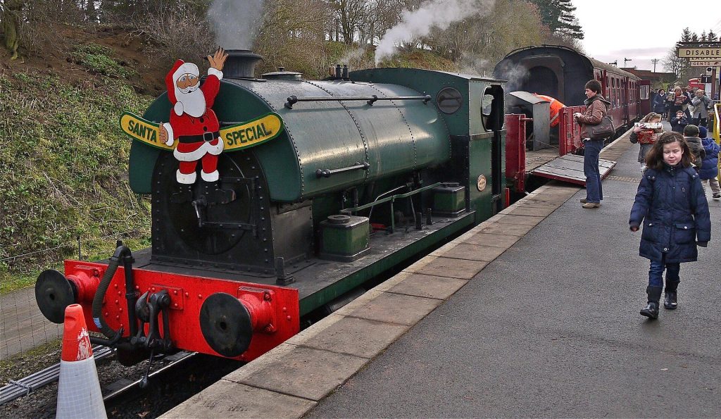 A green steam engine with a Santa Special headboard at Pitsford and Brampton station on the Northampton and Lamport Railway