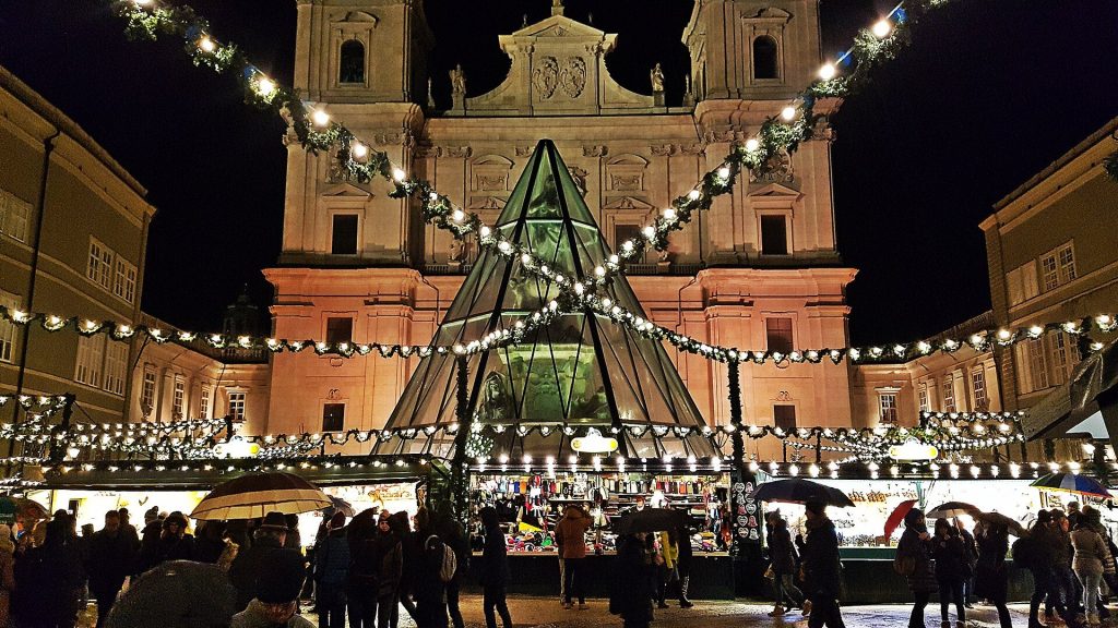 Christmas market stalls and garlands of lights in front of Salzburg Cathedral at night