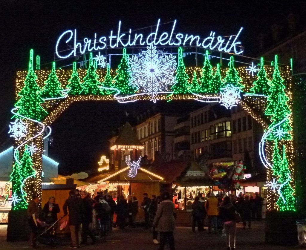 The illuminated Christkindelsmarik entrance arch at the Strasbourg Christmas market on Place Broglie at night