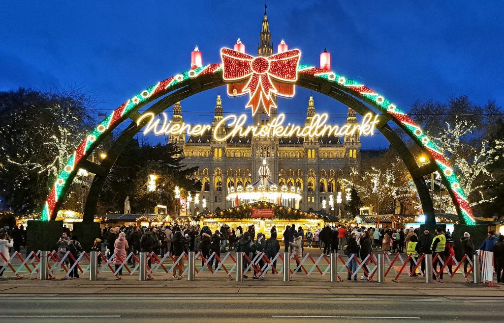 The lit Wiener Christkindlmarkt arch in front of Vienna City Hall on Rathausplatz at dusk